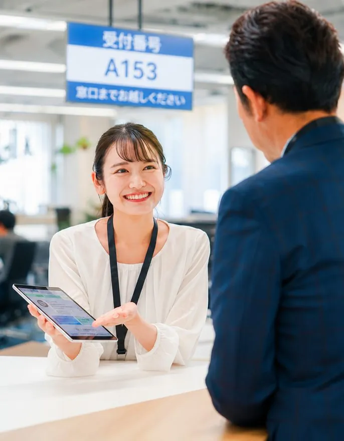 窓口で案内するスタッフ